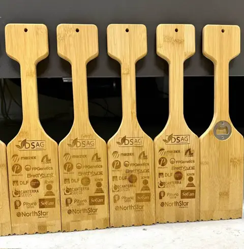 Wooden grill scrapers laser-engraved with multiple sponsor and brand logos